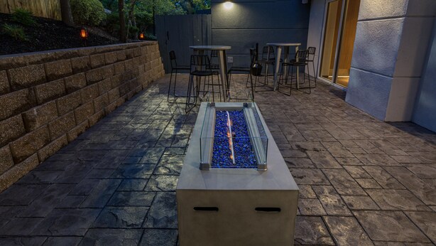An outdoor patio with a rectangular water feature, stone steps, and seating areas. - Fairfield Inn by Marriott Raleigh Airport/RTP (Morrisville)