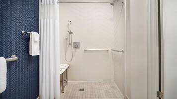 Un bagno moderno con doccia, asciugamano e lavandino.