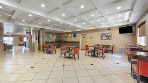 A spacious indoor area with multiple tables and chairs, a kitchen area, and a television mounted on the wall. - Comfort Inn & Suites Orem - Provo (Orem)