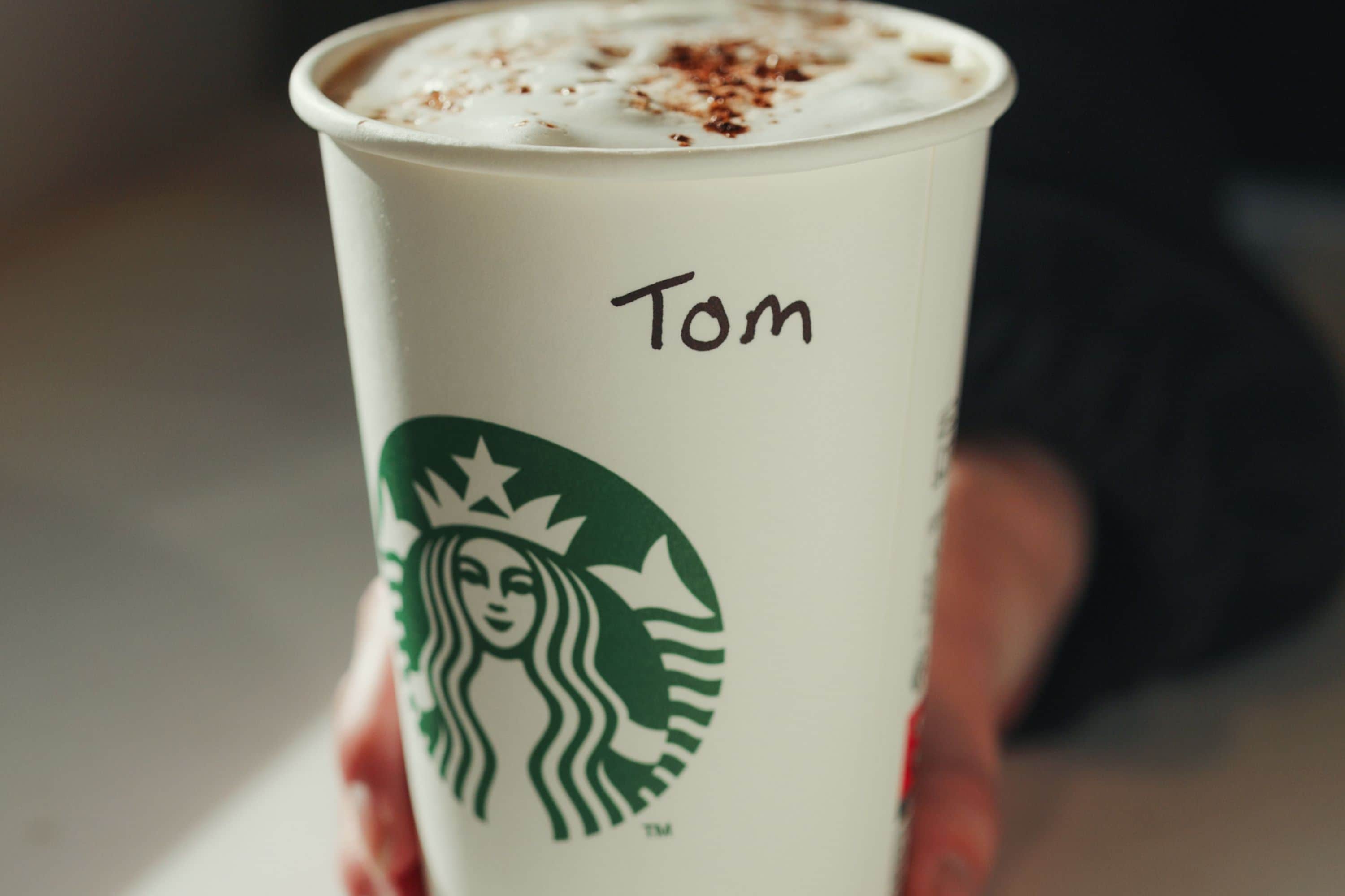 A Starbucks cup with the name 'Tom' written on it.