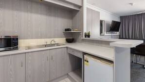 Une cuisine moderne équipée d’un four à micro-ondes, d’un évier et d’un réfrigérateur encastré.