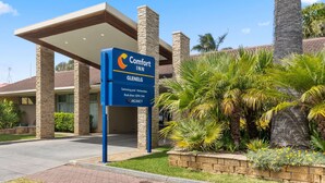 Une enseigne « Comfort Inn » indiquant les équipements disponibles, notamment une piscine et des cuisines américaines.