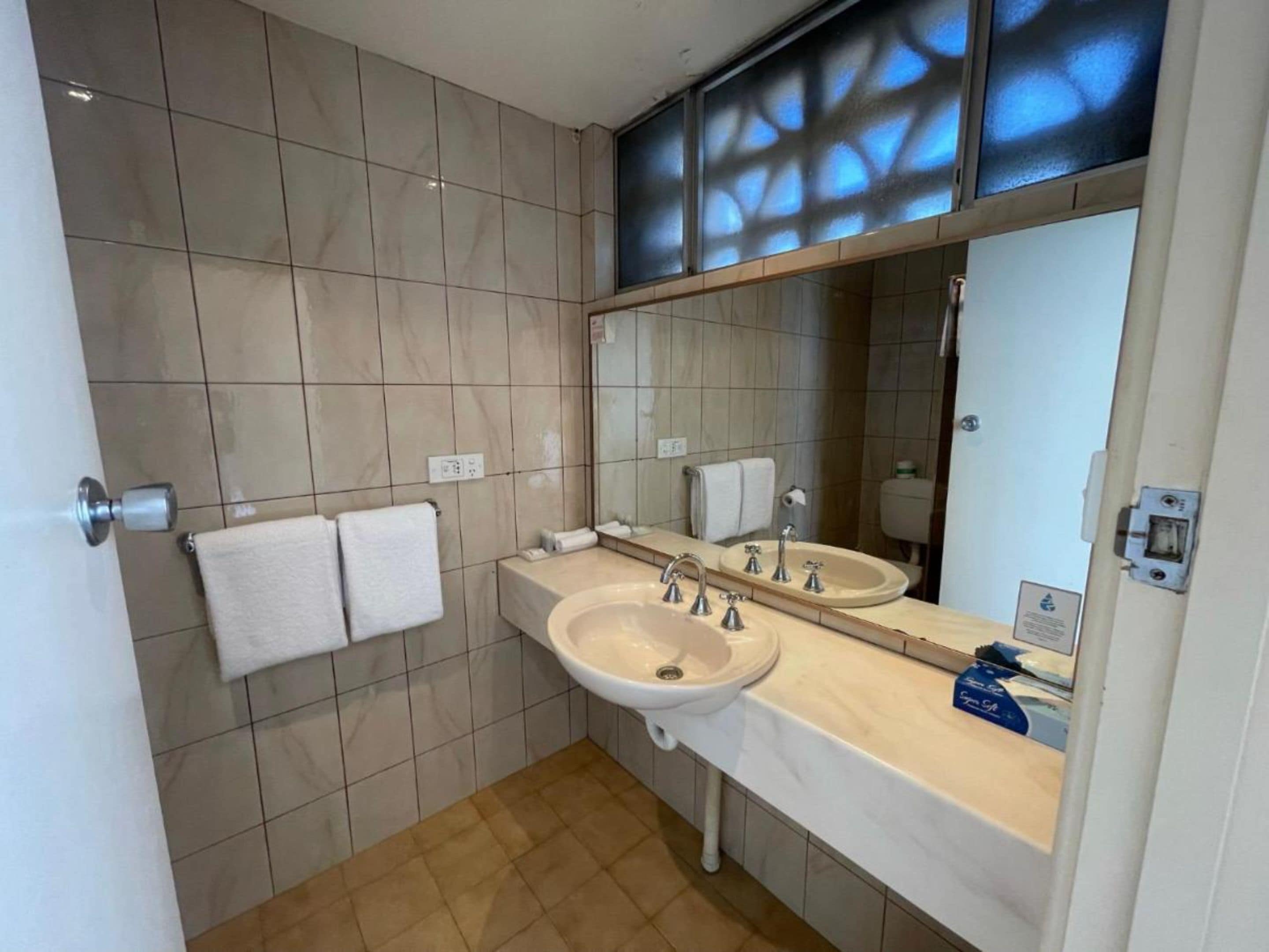 Ein modernes Badezimmer mit zwei Waschbecken, einem großen Spiegel und einer Toilette.