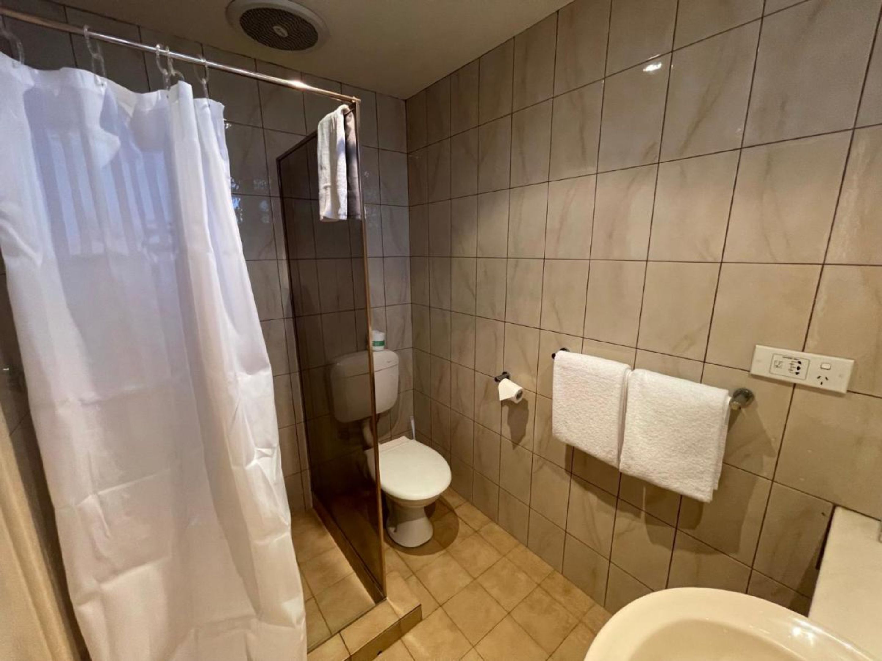 Un baño con ducha, inodoro y lavamanos.