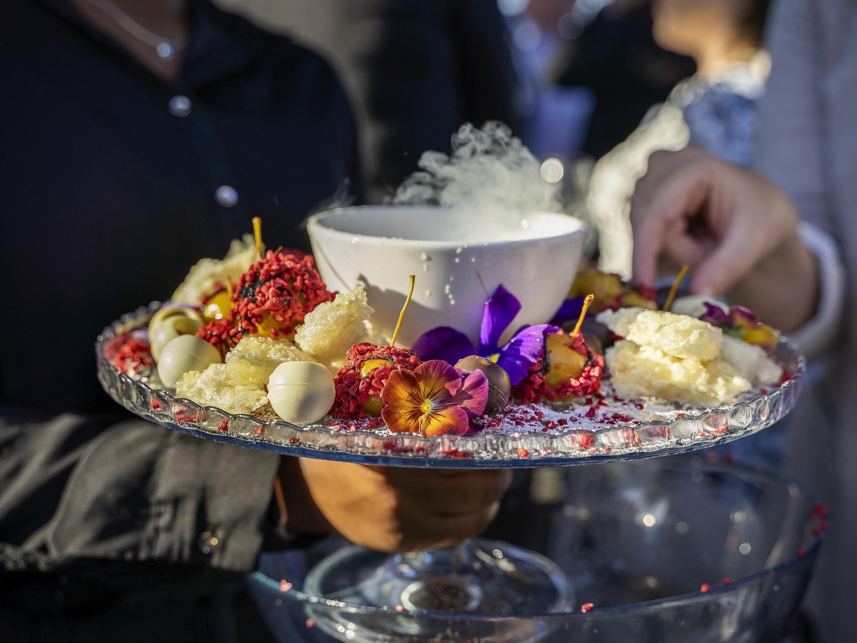Un plato de postres con un bol de helado y diferentes adornos.