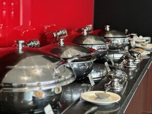 A buffet setup with multiple serving stations, each with a covered pot and a ladle. - Adelaide Rockford (Adelaide)