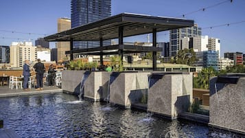 Una piscina al aire libre, sillones reclinables de piscina