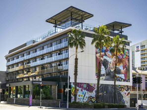 A modern building with a glass facade, a mural on the side, and a sign for 'rockford' on the ground floor. - Adelaide Rockford (Adelaide)