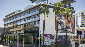 Un edificio moderno con fachada de vidrio, un mural en la pared y un cartel que dice 'rockford' en la planta baja.