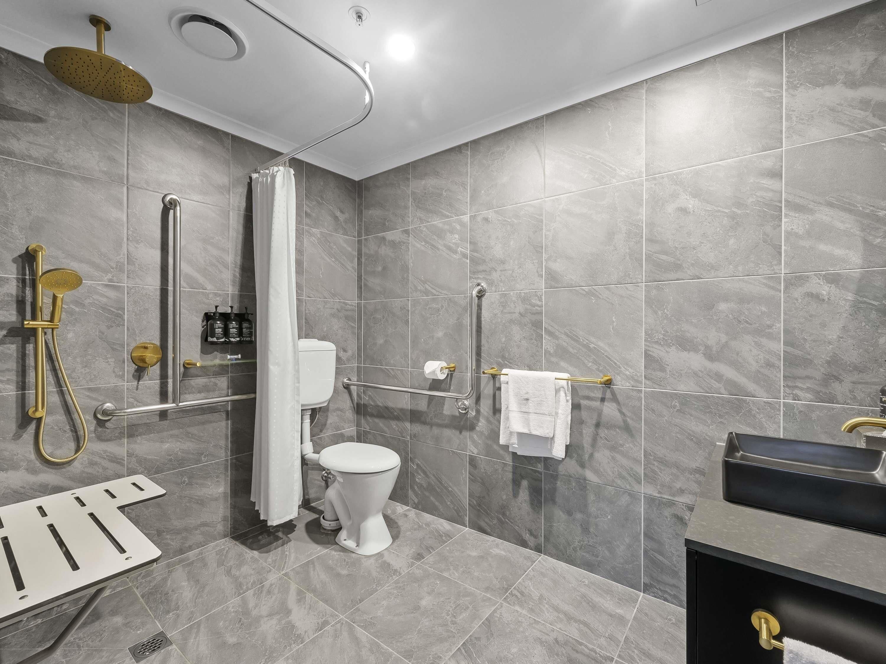 A modern bathroom with a shower, toilet, and sink.