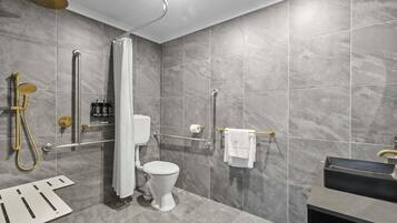 A modern bathroom with a shower, toilet, and sink.