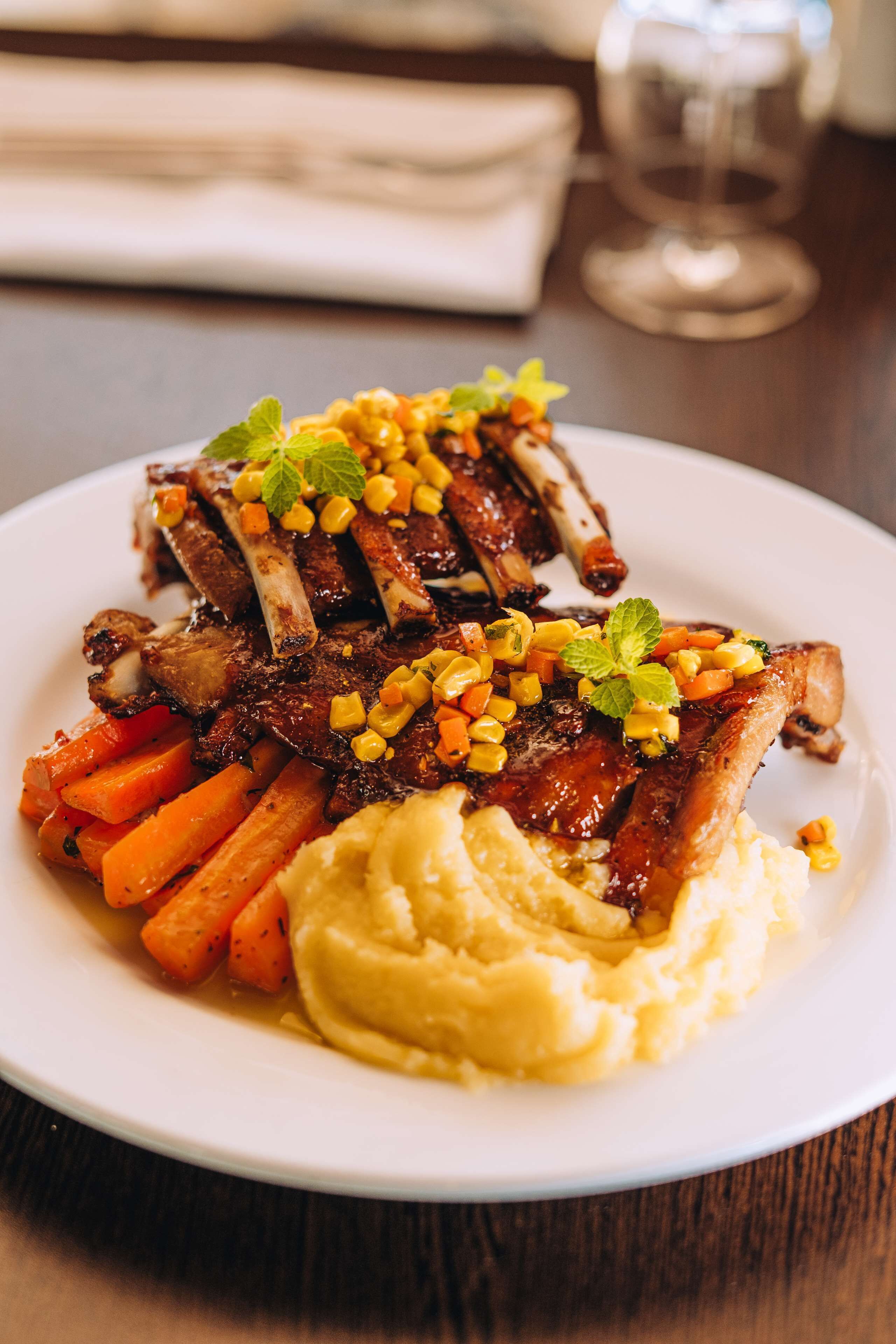 A plate of food with meat, carrots, and mashed potatoes.