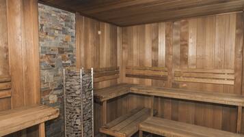 Un sauna avec des bancs en bois et un mur en pierre.