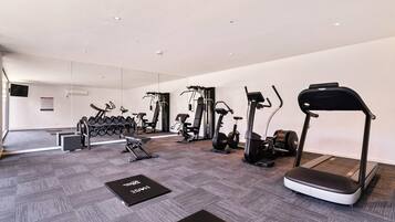 A modern gym with various exercise equipment, including treadmills, elliptical machines, and free weights.