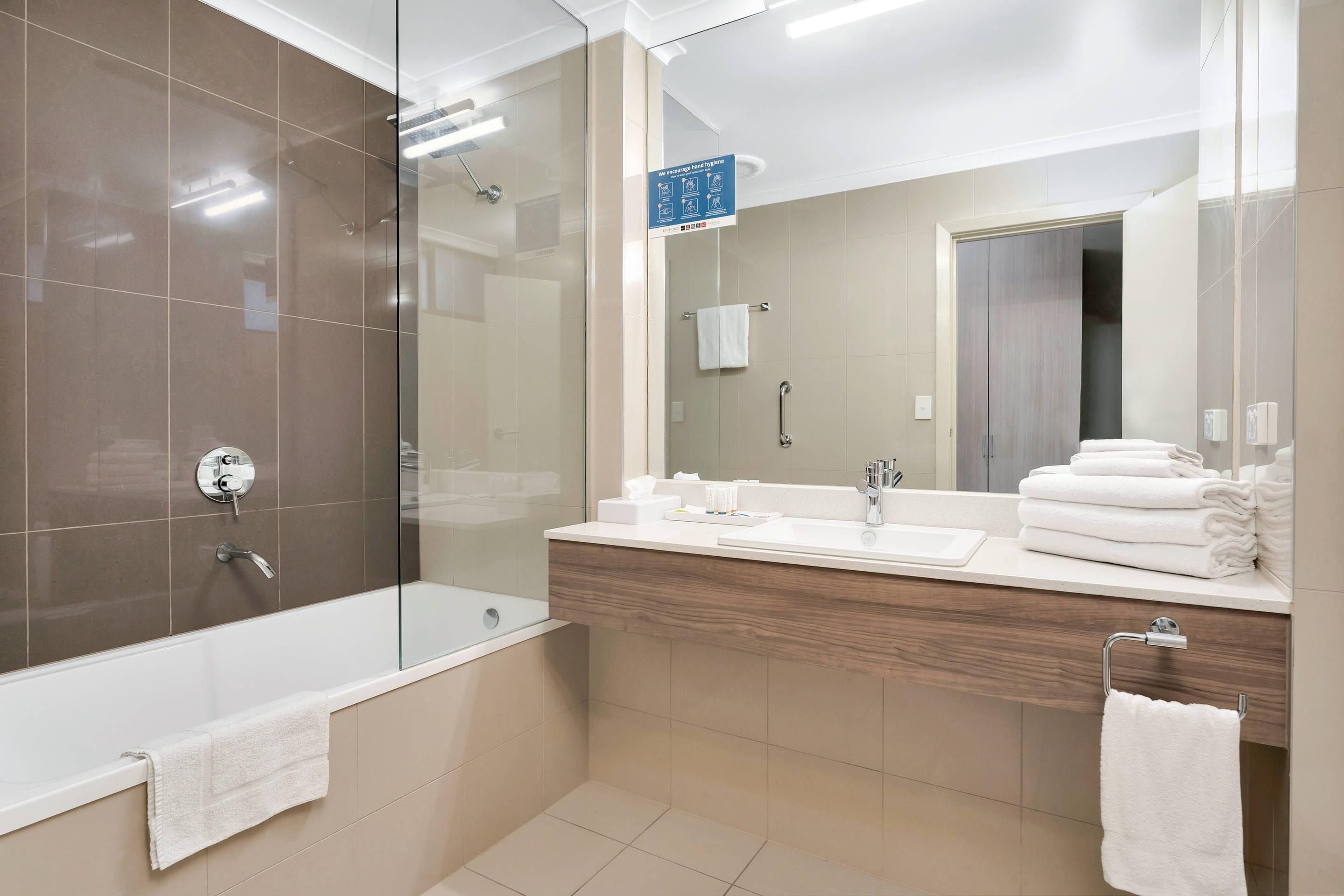 Un baño moderno con bañera, ducha de vidrio y tocador con espejo.