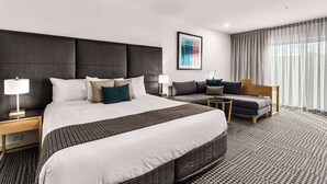 A modern hotel room with a large bed, a sofa, a desk, and a chair. - Quality Hotel Parklake Shepparton (Shepparton)