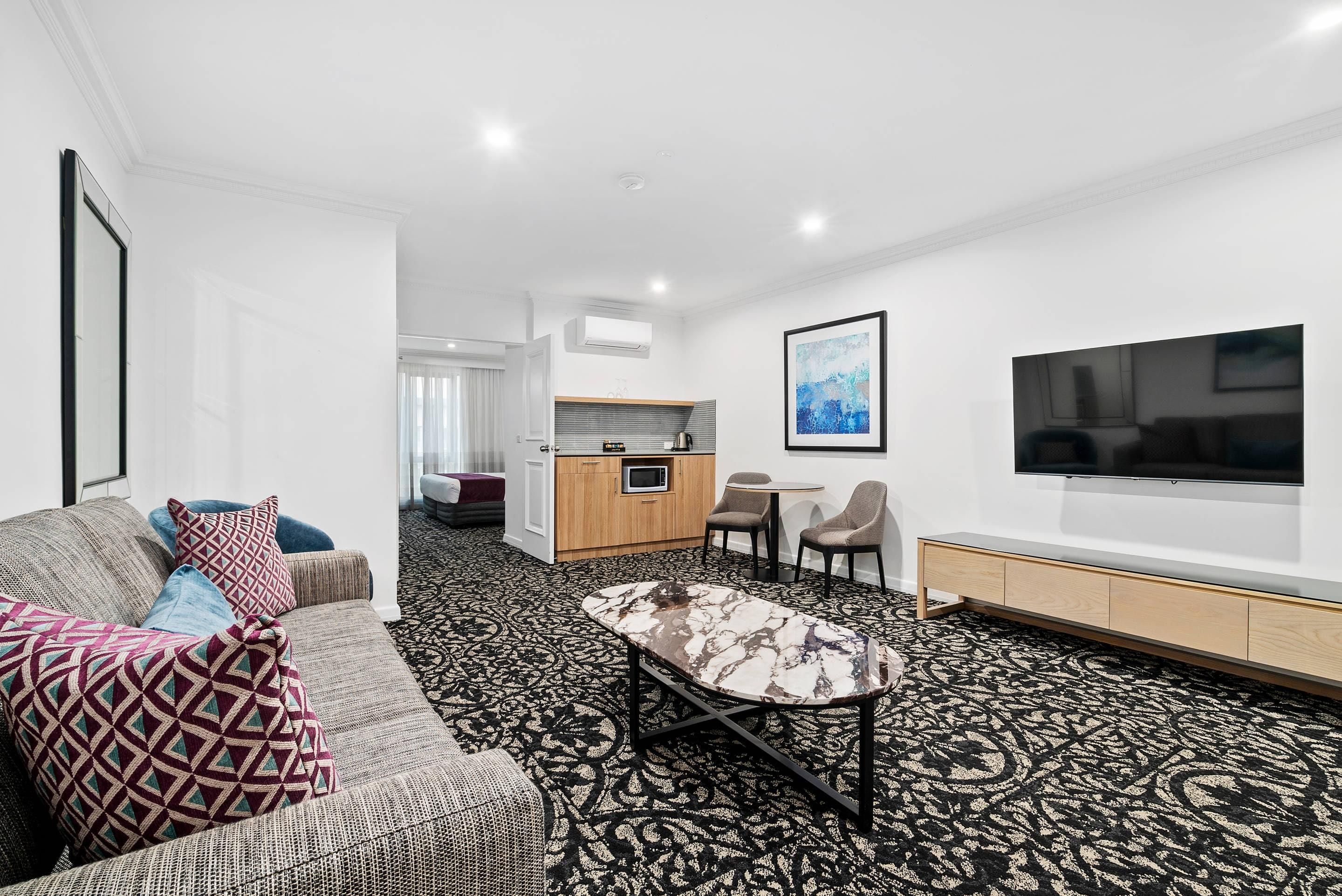 A modern living room with a sofa, patterned rug, and a coffee table.