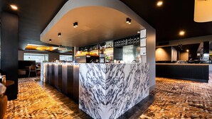 A marble bar with a cash register, shelves with liquor bottles, and a patterned carpet. - Quality Hotel Parklake Shepparton (Shepparton)