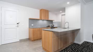 Une cuisine moderne avec des meubles en bois, une hotte en acier inoxydable et un évier encastré.