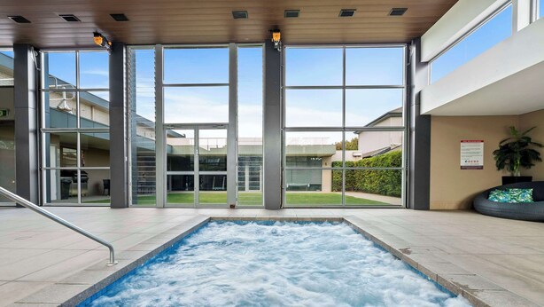 A spa area with a hot tub, large windows, and a view of the outside. - Quality Hotel Parklake Shepparton (Shepparton)
