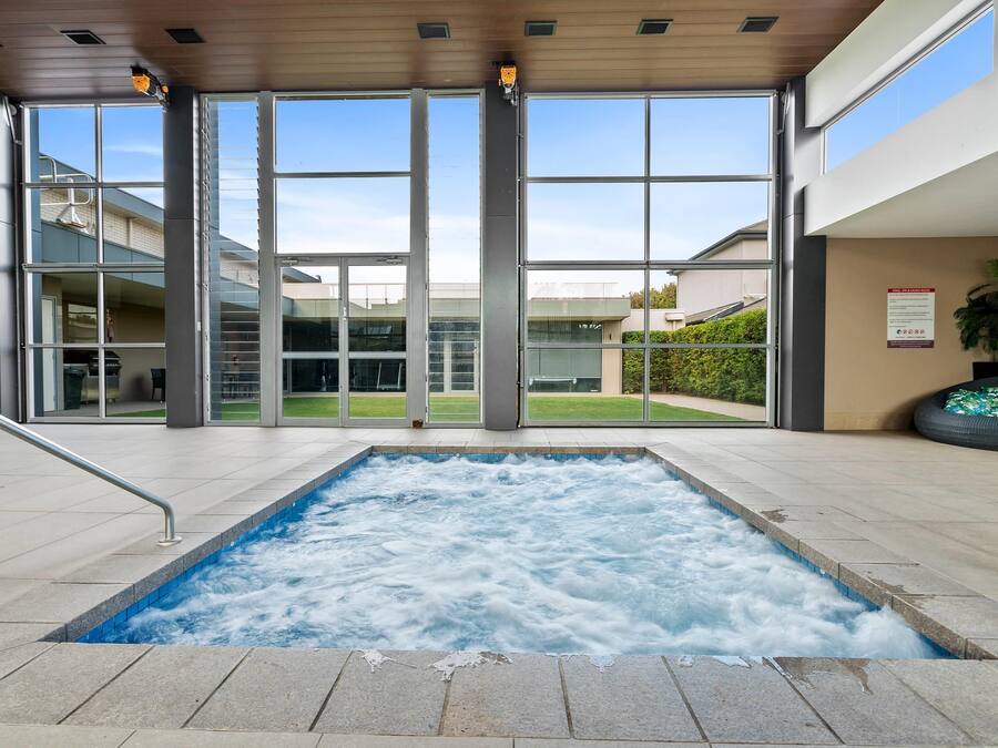A hot tub area with a view of the outside through large glass doors.