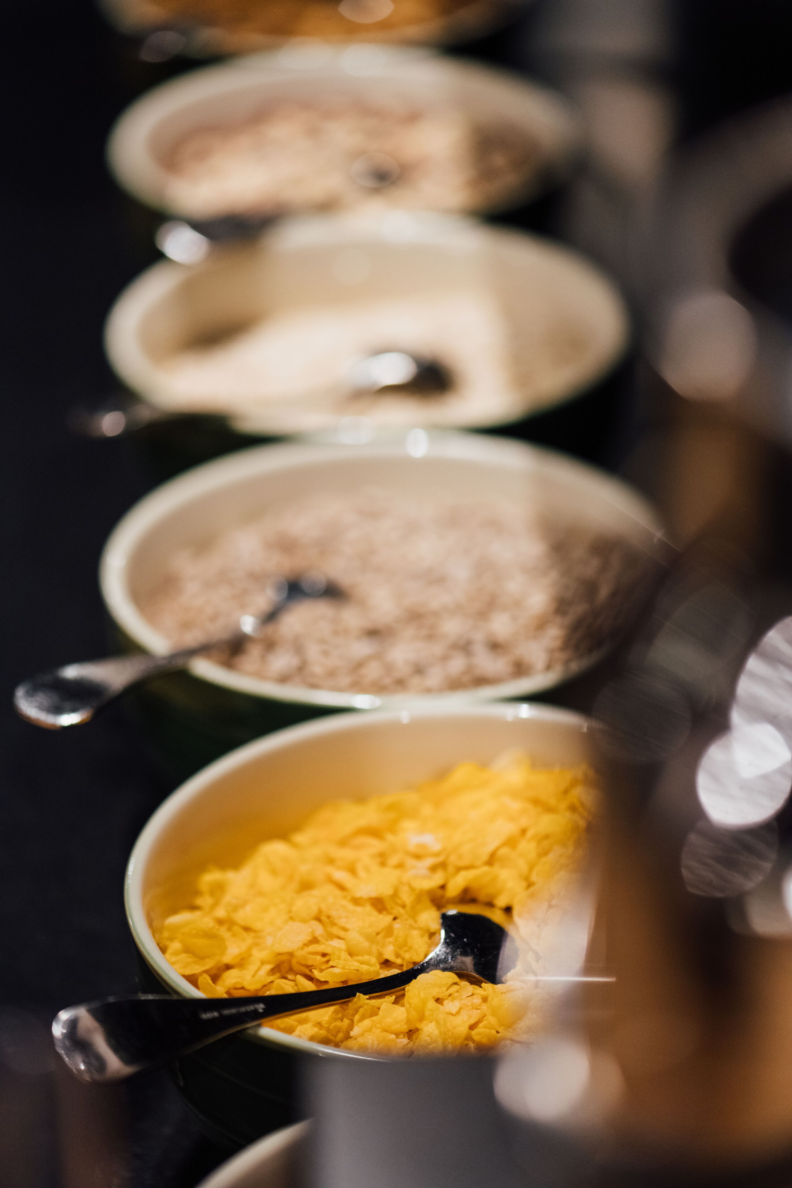 Une série de bols contenant différents aliments, chacun accompagné d’une cuillère.