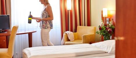 Une chambre d’hôtel avec un lit, une chaise, un bureau et un téléviseur.