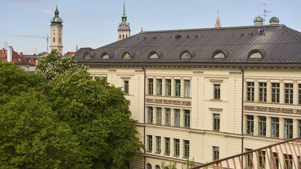 A historic building with a prominent clock tower and green domes. - Hotel Concorde München (Munich)