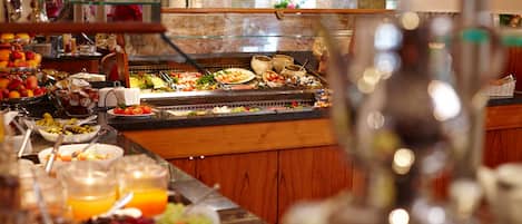 A buffet with various food items and beverages.