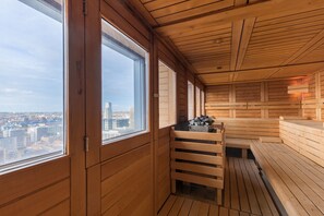 A sauna room with wooden benches and a view of the cityscape through large windows. - Thon Hotel Brussels City Centre (Brussels)