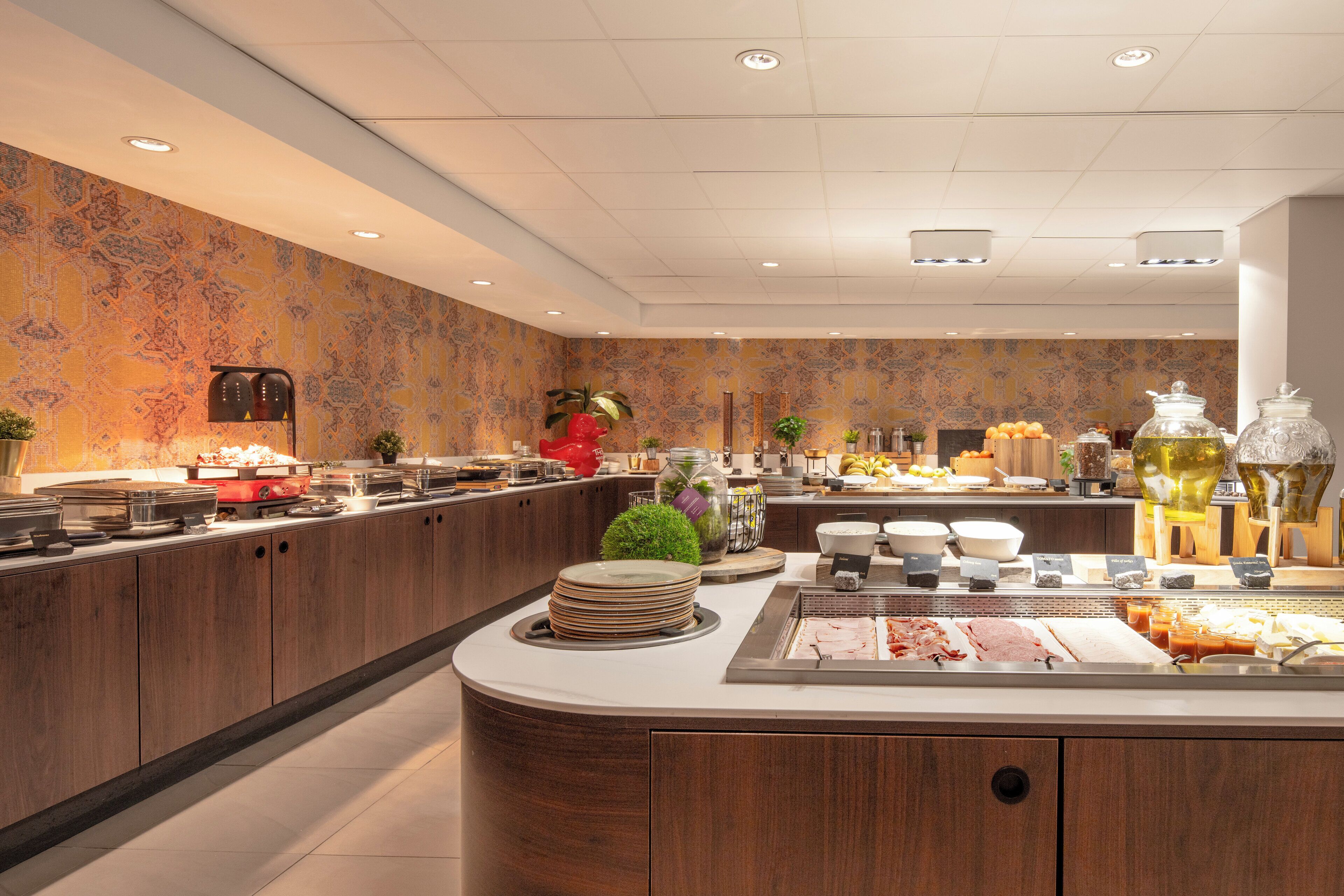 A modern breakfast buffet with a variety of food options, a decorative wall, and a clean, well-lit environment.