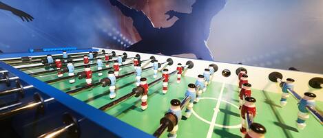 Una mesa de fútbol de mesa con borde azul y diseño de campo de fútbol.