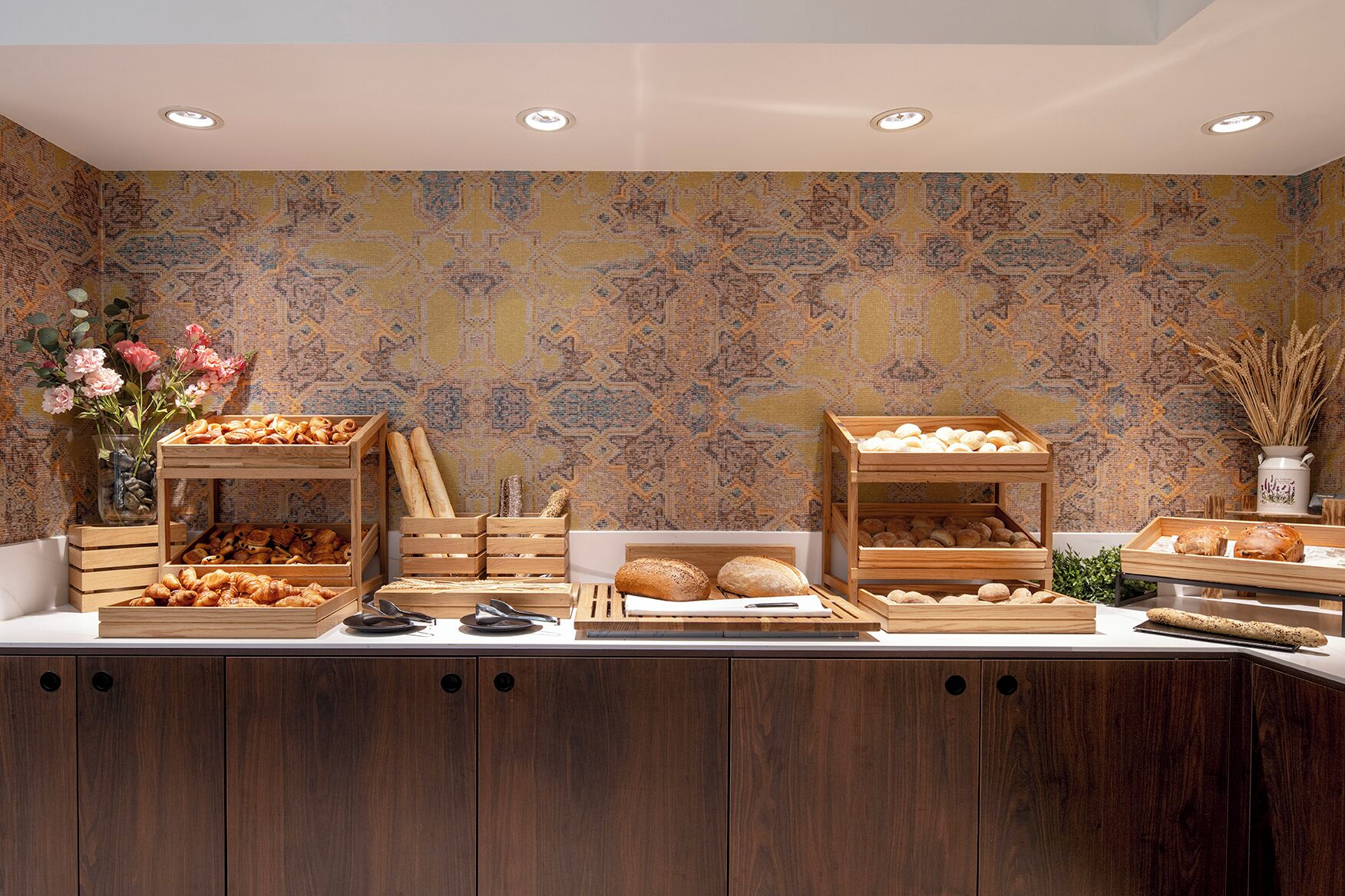 A buffet setup with various food items and a decorative wall.