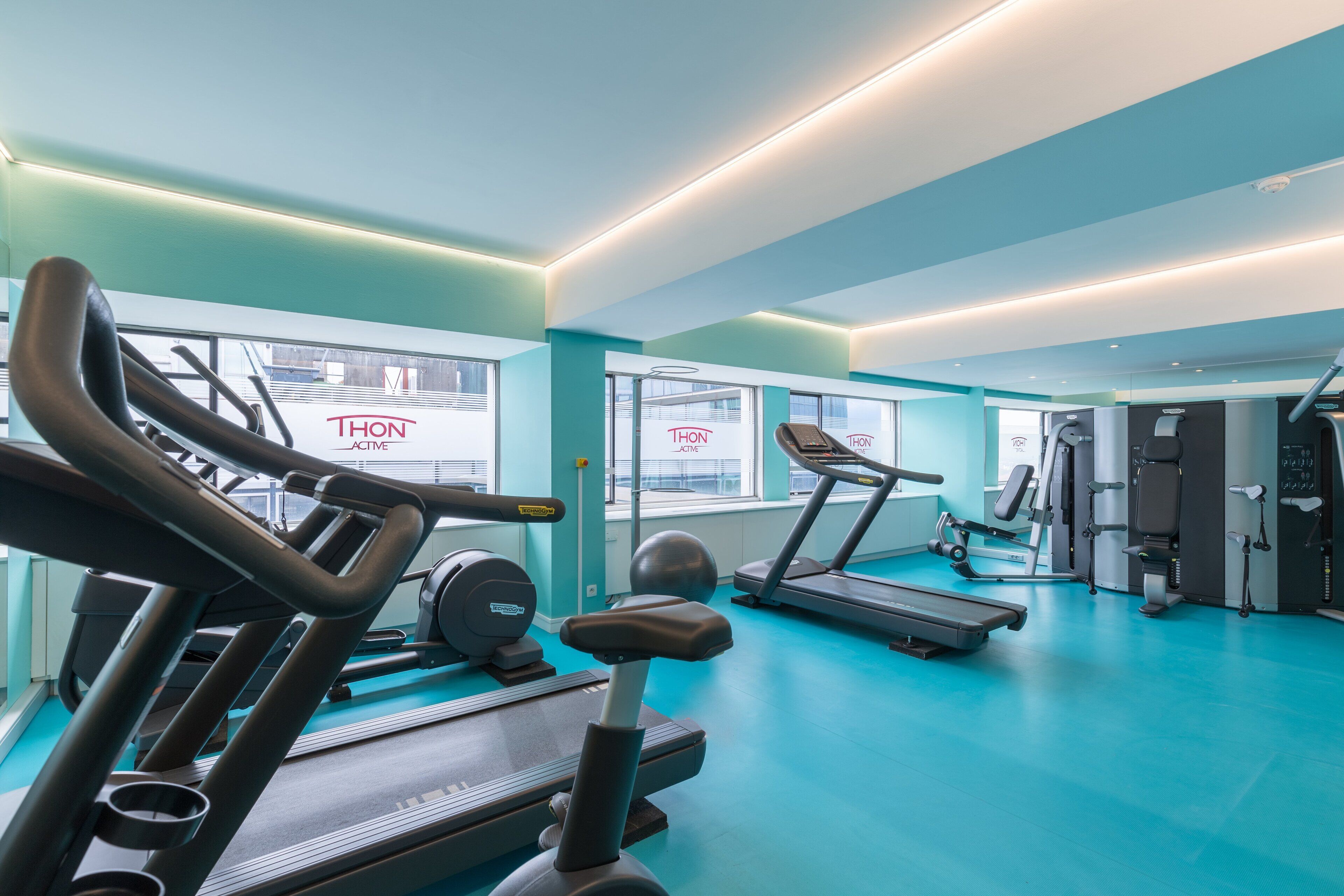 A gym with treadmills, exercise bikes, and weight machines.