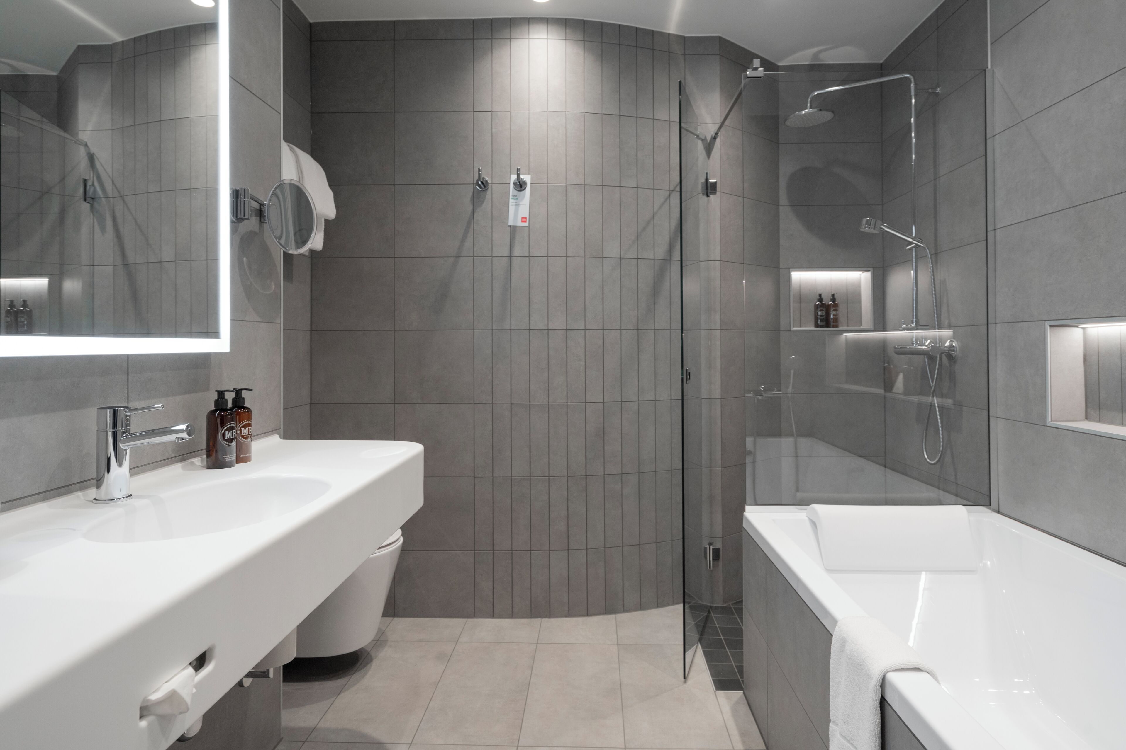 Un bany modern amb dutxa, un lavabo i un mirall.