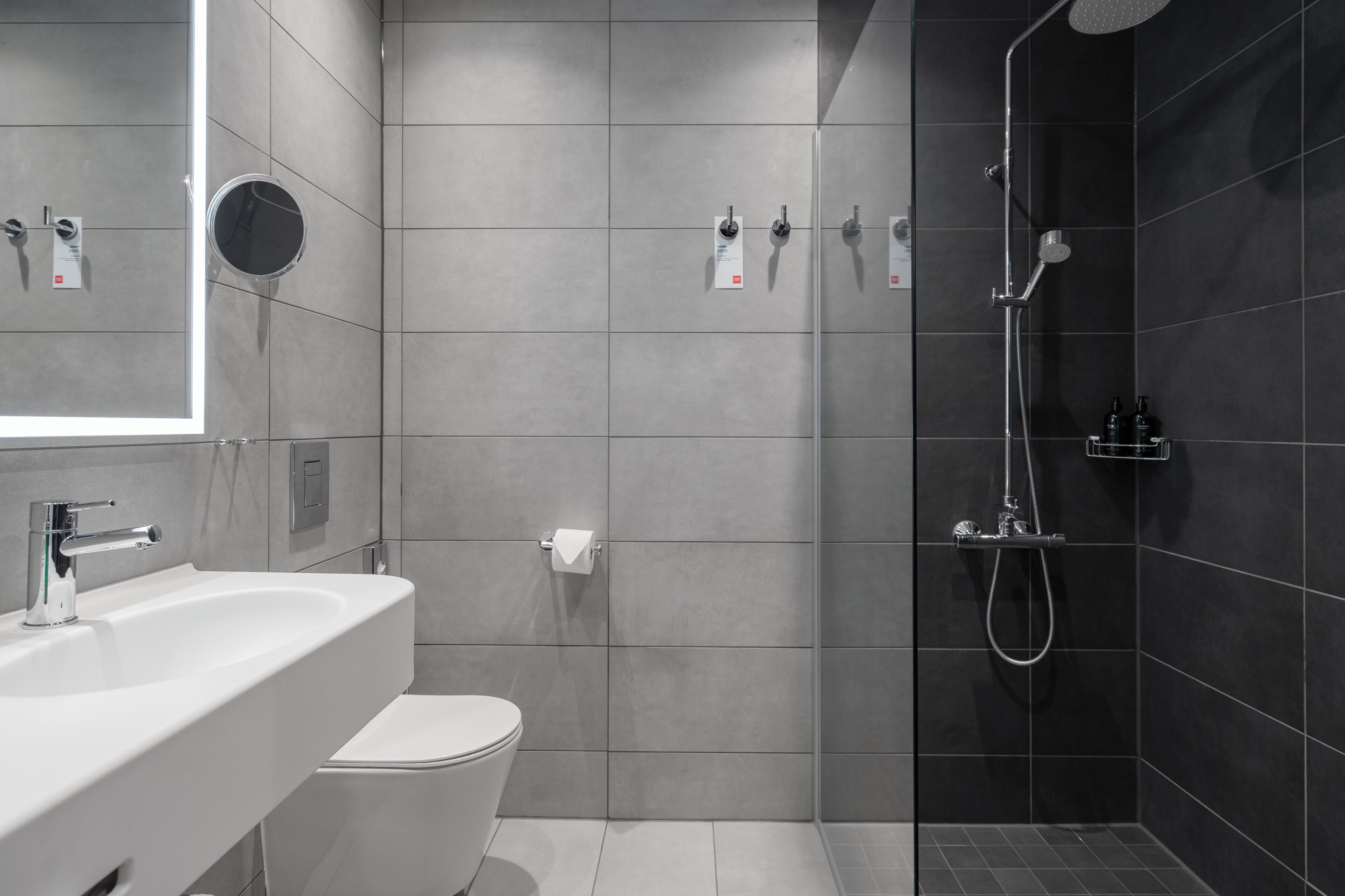 Un baño moderno con lavamanos, inodoro y ducha.