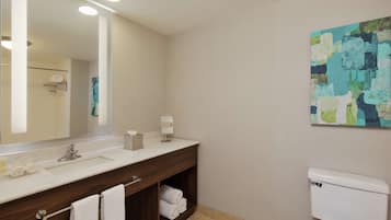Un baño moderno con un espejo grande, un lavabo, un inodoro y un perchero para toallas.