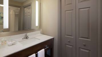 A bathroom with a white sink, a mirror, and a wooden cabinet.