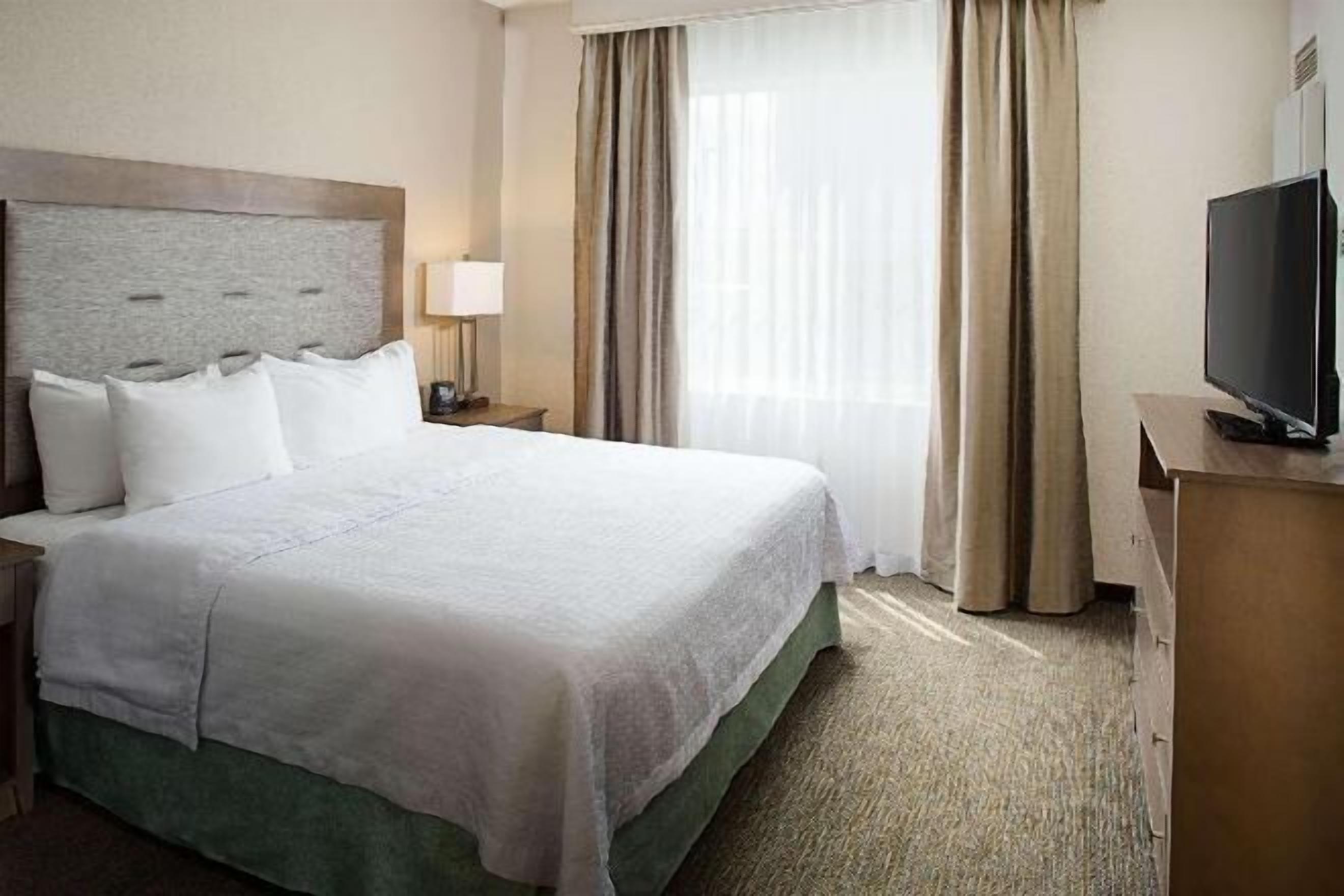 Premium bedding, desk, laptop workspace, blackout drapes