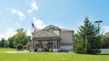 A Holiday Inn Express hotel with a brick facade, an American flag, and a covered entrance.