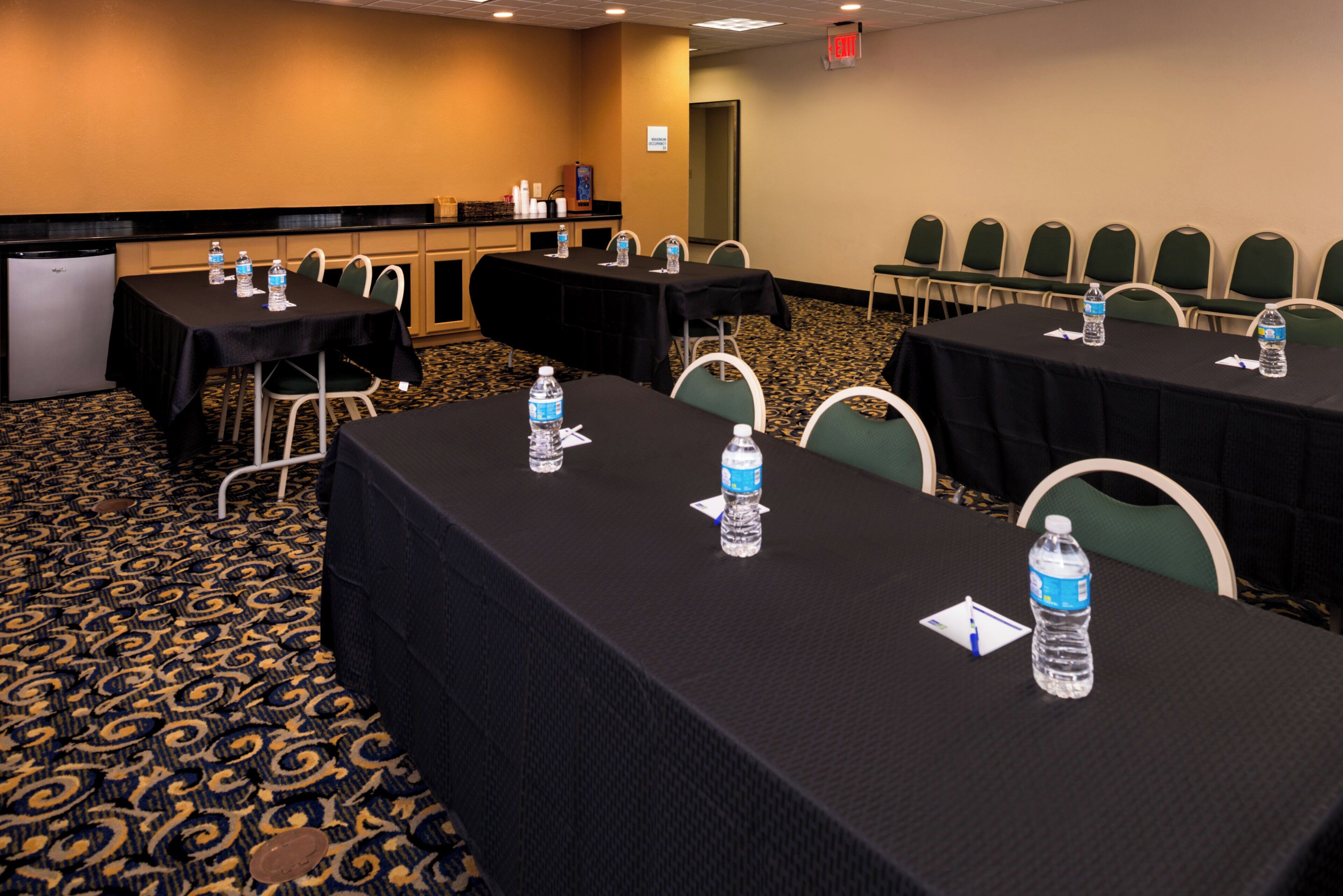 A conference room with tables set up for meetings, equipped with water bottles and nameplates.