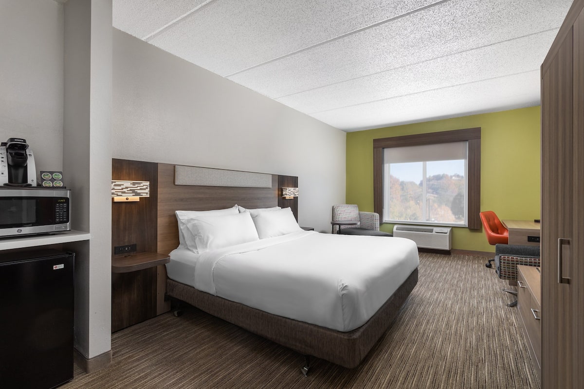 Ein Hotelzimmer mit Bett, Schreibtisch mit Mikrowelle, Stuhl und Fenster mit Blick.