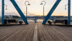 A wooden deck with benches and street lamps, overlooking a bridge and a sunset. - Holiday Inn Express Hotel & Suites Chattanooga-Lookout Mtn by IHG (Chattanooga)