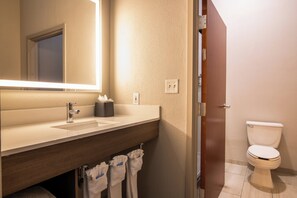 A modern bathroom with a white sink, mirror, and toilet. - Holiday Inn Express & Suites College Station by IHG (College Station)