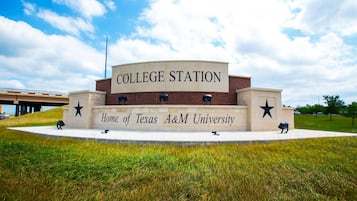 A building labeled "COLLEGE STATION Home of Texas A&M University" with a star emblem and a flagpole.