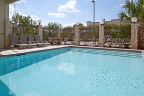 A swimming pool with lounge chairs and a fence. - Holiday Inn Express & Suites College Station by IHG (College Station)