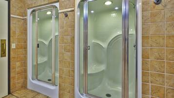 A bathroom with two glass-enclosed shower stalls and a tiled floor.