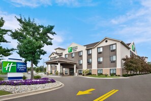 A Holiday Inn Express & Suites building with a modern design, featuring a large entrance and a parking area with directional arrows. - Holiday Inn Express Hotel & Suites Belleville by IHG (Belleville)