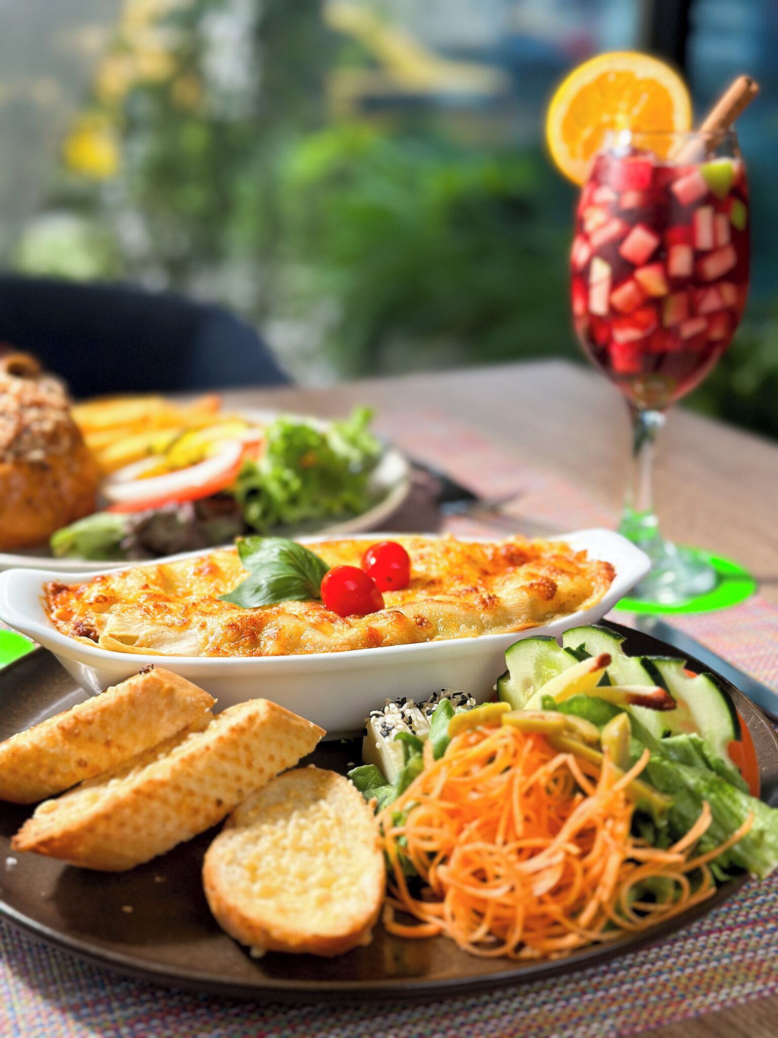 Un repas composé d’un plat de pâtes, d’un verre à boire et d’une assiette de légumes et de pain.