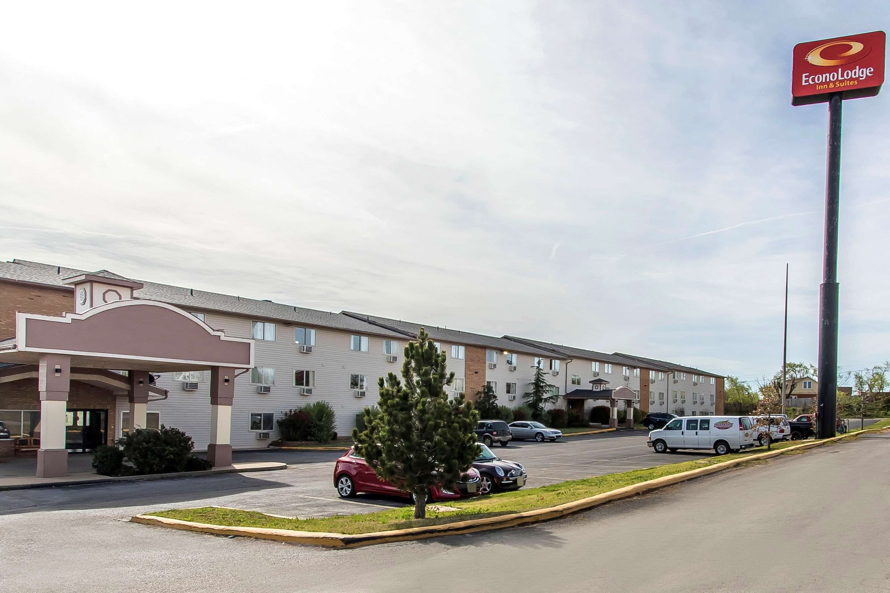 A hotel with a parking lot, a covered entrance, and a sign for EconoLodge Inn & Suites.